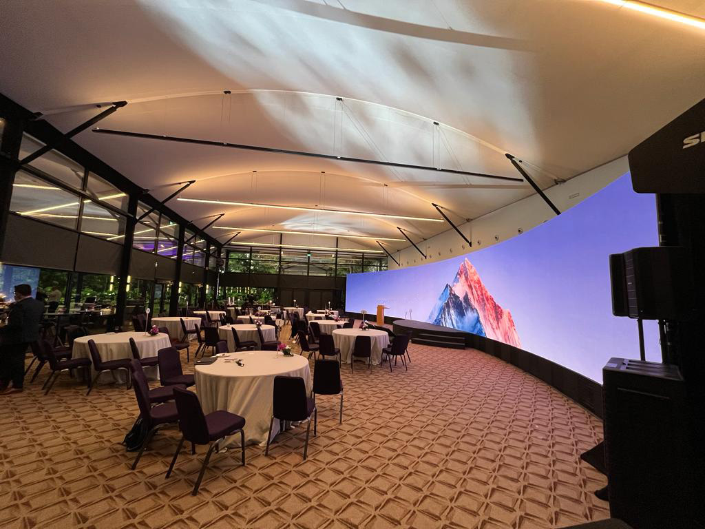 Corporate presentation with wide LED video wall and professional audio setup